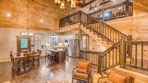A spacious wooden interior with a central island, a staircase, and a dining area. - Modern Rustic 3BR & Loft, Hot Tub, GR and Fire Pit (Ellijay)