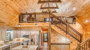 A spacious kitchen with a central island, stainless steel appliances, and a herringbone tile backsplash. - Modern Rustic 3BR & Loft, Hot Tub, GR and Fire Pit (Ellijay)