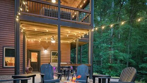 A cabin with a stone fire pit, outdoor seating, and string lights. - Modern Rustic 3BR & Loft, Hot Tub, GR and Fire Pit (Ellijay)