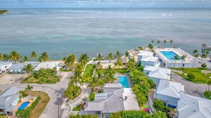 A coastal resort with multiple buildings, a swimming pool, and a view of the ocean.