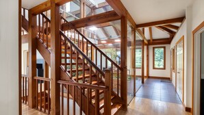 Un escalier en bois, protégé par une paroi de verre, mène au deuxième étage.