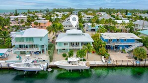 A coastal residential area with houses, a dock, and a boat.
