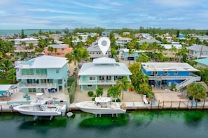 Uma área residencial à beira-mar, com casas, um cais e um barco.