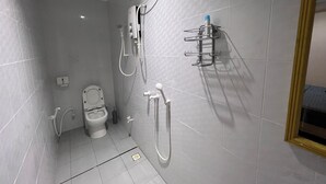 A small, modern bathroom with a toilet, shower, and sink.