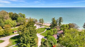 A coastal property with a paved driveway, a small building, and a view of the sea. - Oak & Clay Haven – Walk to Bar & Beach! (Fort Gratiot)