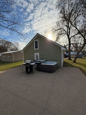 Une maison dotée d’un patio couvert, d’un barbecue et d’un jacuzzi.