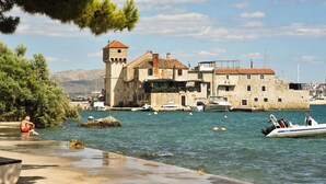 A coastal town with stone buildings, a tower, and boats on the water. - B studio apartment near the beach with sea view (Kastel Gomilica)