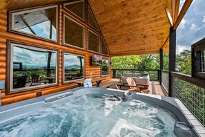 A hot tub on a wooden deck with a view of a mountainous landscape. - New Mtn Luxe Cabin | Hot Tub | Mountain Views! (Sevierville)
