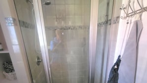 A bathroom with a glass-enclosed shower, a white toilet, and a towel rack. - Serene Adult-Only Suite in the Heart of Houston (Houston)