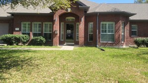 A brick house with a front entrance, a garage, and a well-maintained lawn. - Serene Adult-Only Suite in the Heart of Houston (Houston)