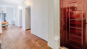 Un couloir avec une porte en bois portant le numéro 3, qui donne accès à une pièce.
