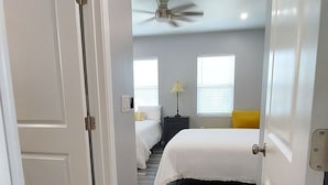 A bedroom with a bed, a nightstand, a lamp, and a ceiling fan. - Opulent 4 Bdrm, Sleeps 12, Minutes From Downtown! (Cincinnati)