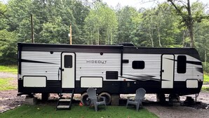 Ein Hideout Wohnmobil mit Schiebetür, kleinem Fenster und Stauraum.