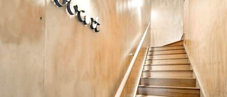 Una escalera de madera con barandilla y un letrero en la pared.