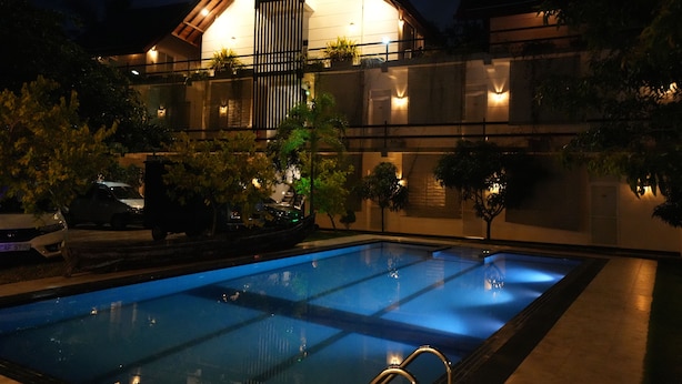 Una piscina con una casa moderna al fondo.