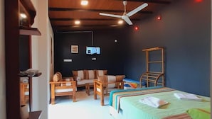 Una habitación con cama, escritorio, silla y televisor.