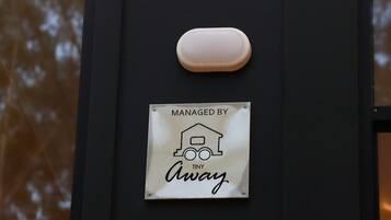 Eine Tür mit einem Schild, das „MANAGED BY TINY Away“ zeigt, und einem kleinen, ovalen Gegenstand darüber.