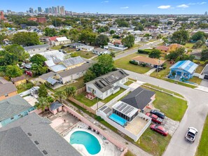 An aerial view of a residential neighborhood with houses, a swimming pool, and a road.