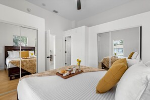 A modern hotel room with a large bed, a breakfast tray, and a view of the outdoors.