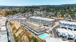 Un hôtel moderne doté d’une grande piscine, de plusieurs étages et offrant une vue sur le quartier résidentiel environnant.