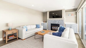 Un salon moderne avec un canapé, une table basse et une table d’appoint.