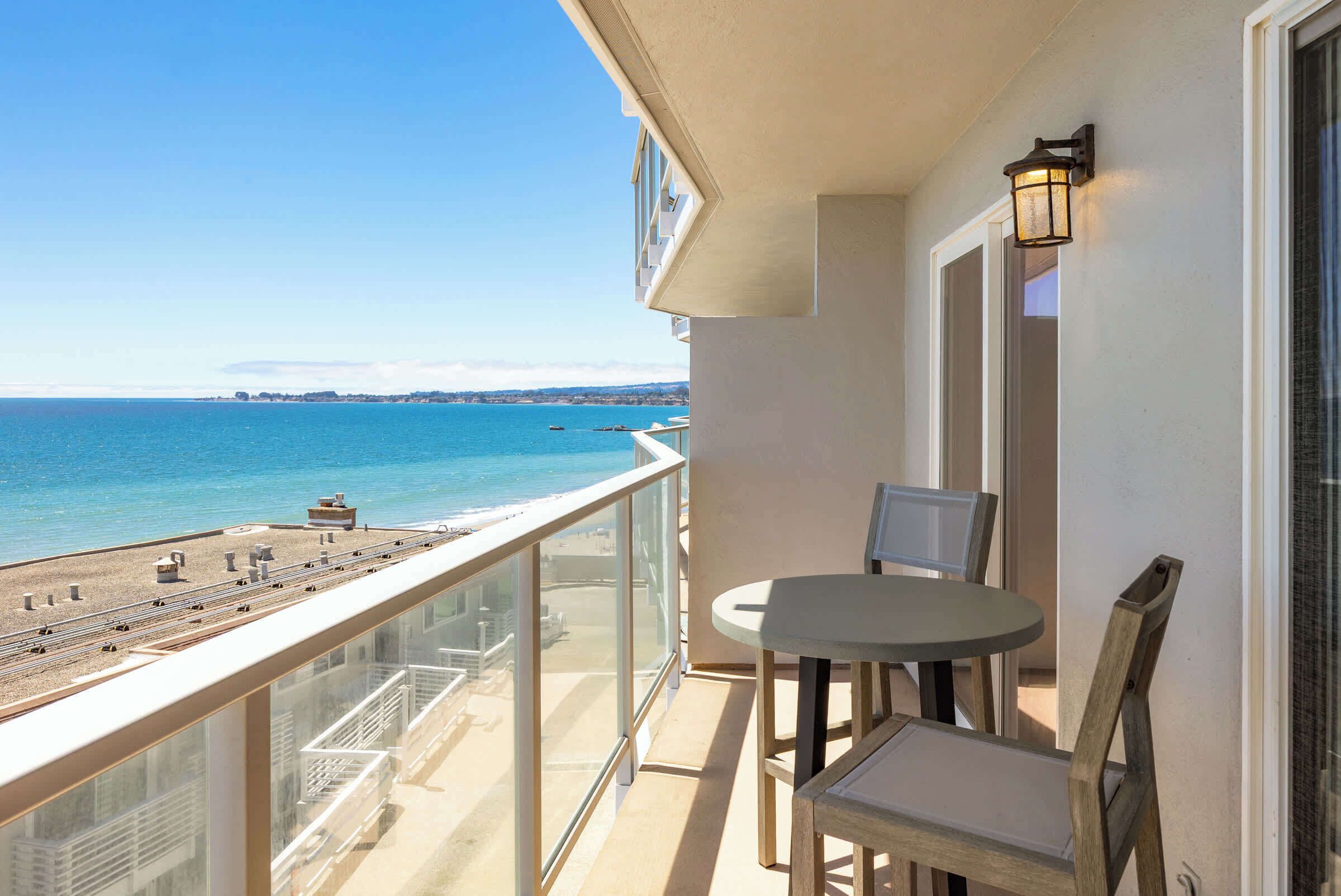 A balcony with a view of the beach and ocean.