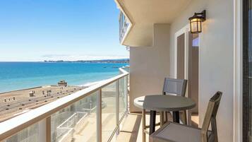 A balcony with a view of the beach and ocean.