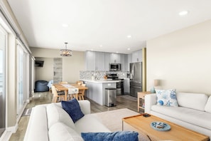 Um apartamento moderno com sala de estar, área de refeições e cozinha.