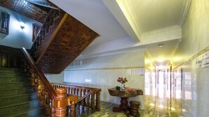 Un magnifique escalier avec des balustrades en bois et un sol en marbre.
