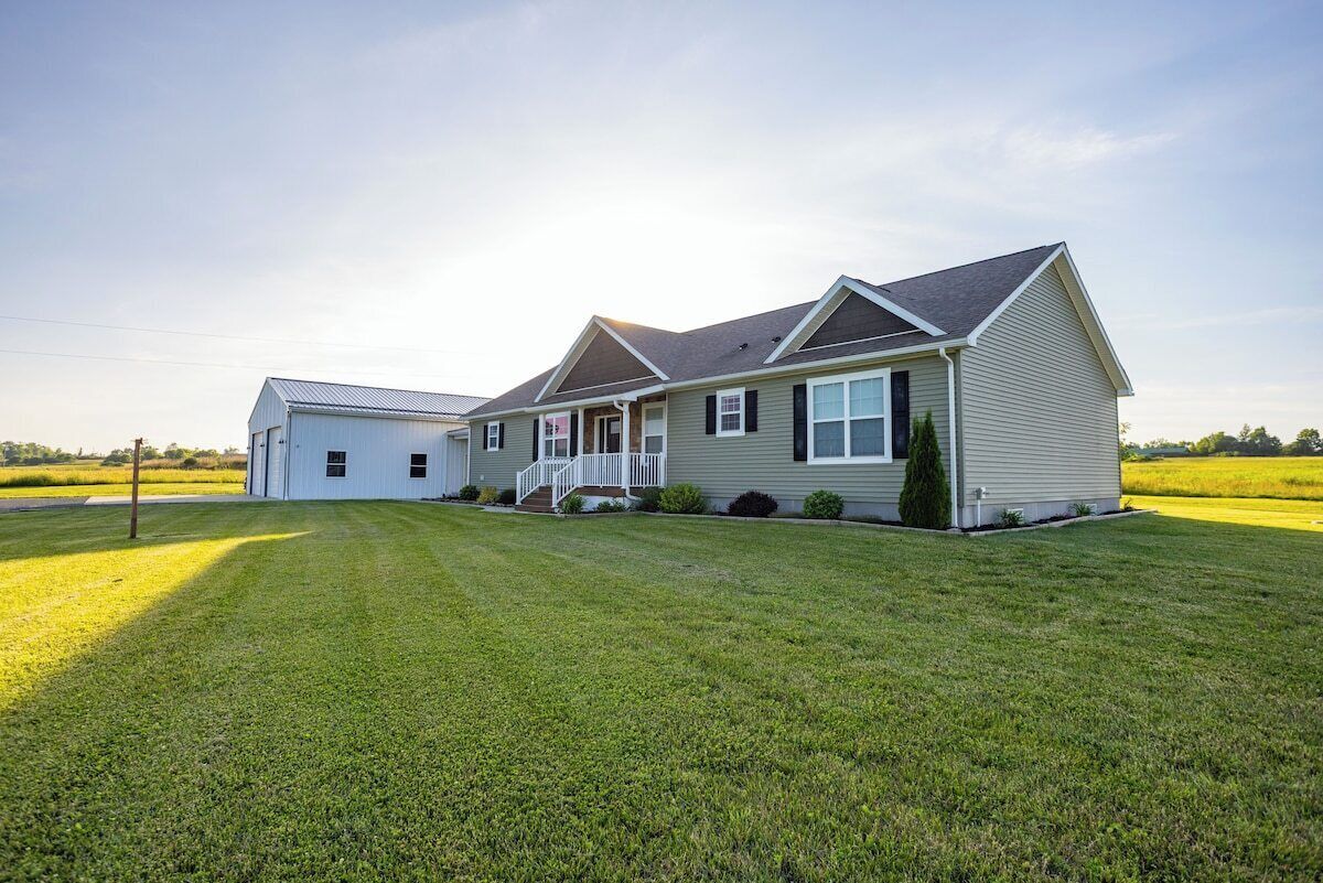 A single-story house with a front porch, a garage, and a well-maintained lawn.