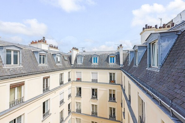 A multi-story building with a courtyard, featuring balconies and dormer windows.