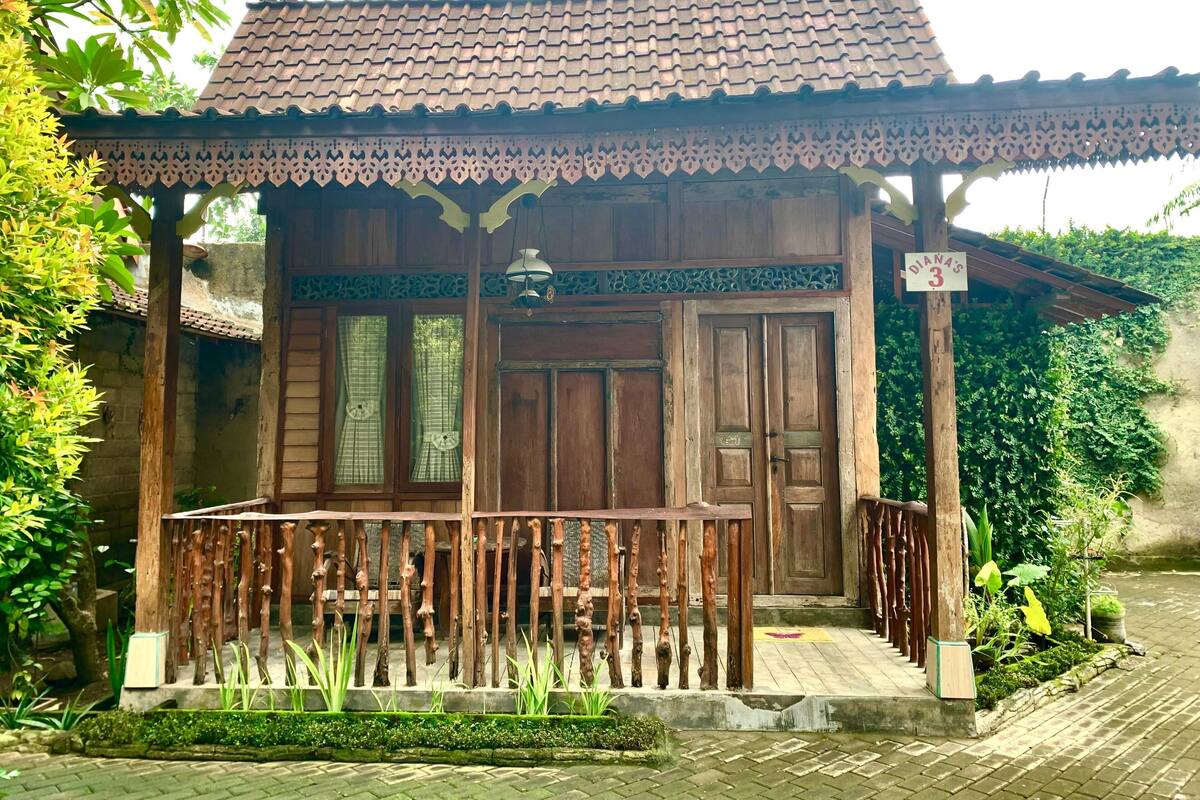 A traditional wooden building with a tiled roof, a wooden porch with a railing, and a sign indicating room number 3.