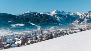 Un paysage montagneux enneigé avec une ville située dans la vallée.