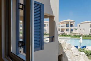 Ein Balkon mit Blick auf einen Swimmingpool und angrenzende Gebäude.