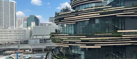 A modern multi-story building with a curved facade, surrounded by other high-rise buildings.
