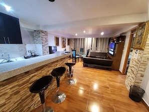 Familieleilighet, flere senger, terrasse, elveutsikt | Oppholdsområde | En 50-tommers smart-TV med digitale kanaler samt strømmetjenester