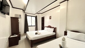 A hotel room with two beds, a TV mounted on the wall, and a window with curtains. - Alocasia El Nido (El Nido)