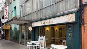 A storefront with a sign reading "CARMELA" and a sign for "FOTO LERMA" indicating photo services. There are outdoor tables and chairs in front of the entrance. - 5 minutes walking distance from Angel Reforma (Ciudad de México)