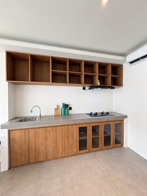 Una cucina moderna con isola integrata, mobili in legno e lavello in acciaio inossidabile.