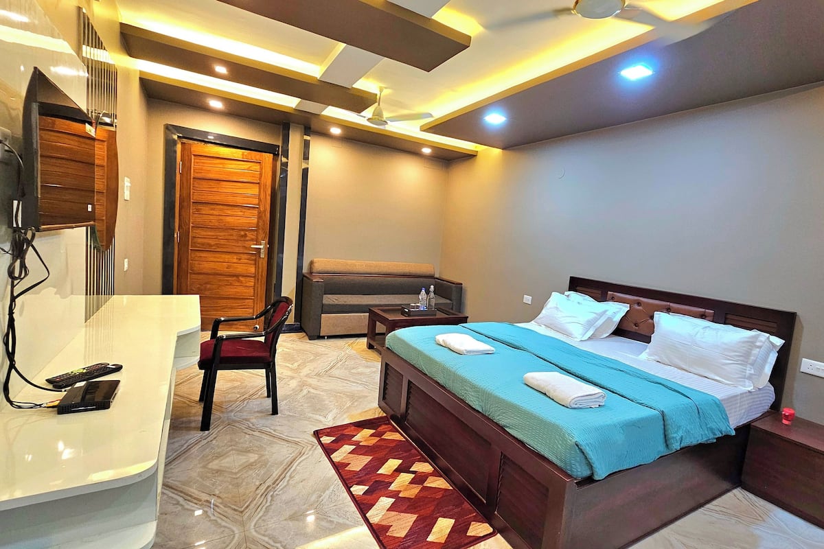 Un dormitorio moderno con cama, mesita de noche y escritorio con silla.