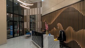 A modern reception area with a marble counter, a seating area, and a decorative wall with vertical slats. - Excellent location and comfort Rest in Absolute Darkness (Lima)
