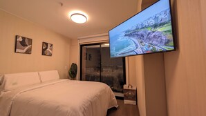 A hotel room with a bed, a TV displaying a scenic view, and a plant. - Excellent location and comfort Rest in Absolute Darkness (Lima)