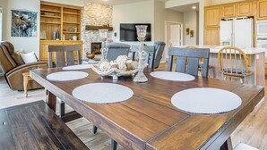 A spacious dining area with a wooden table, chairs, and a fireplace. - Golf & Mountain Views - Retreat in Clio (Clio)