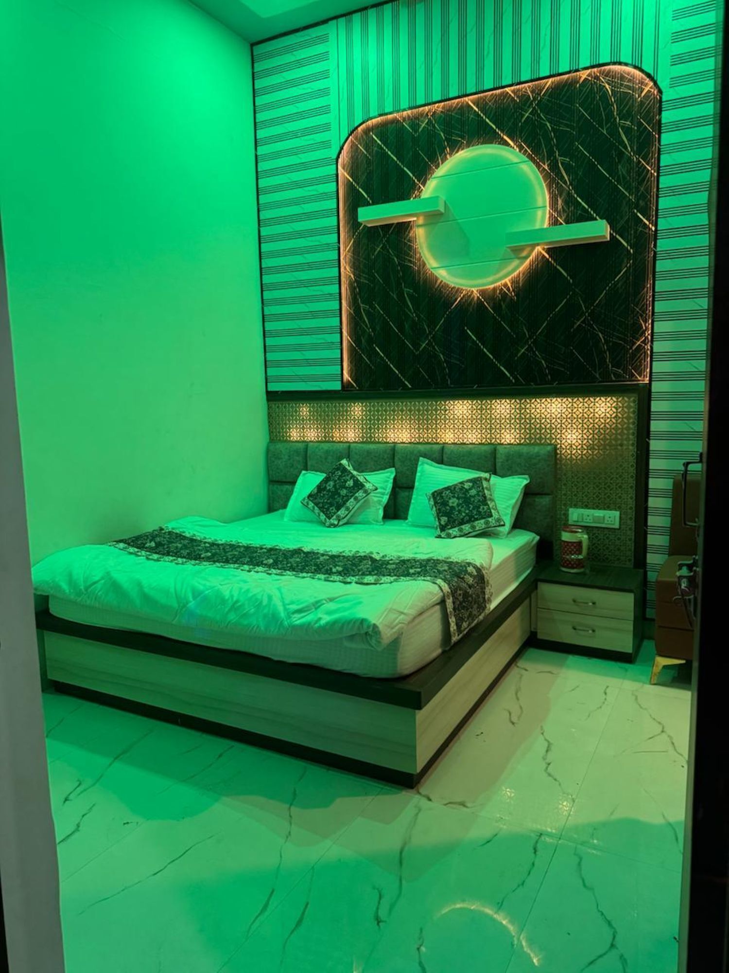 Un dormitorio moderno con cama, mesitas de noche y una pieza de arte único en la pared.