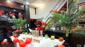 A reception desk decorated with red and white balloons, a potted plant, and a sign with text. - Sanwariya Guest House And Resort (Danta Ramgarh)