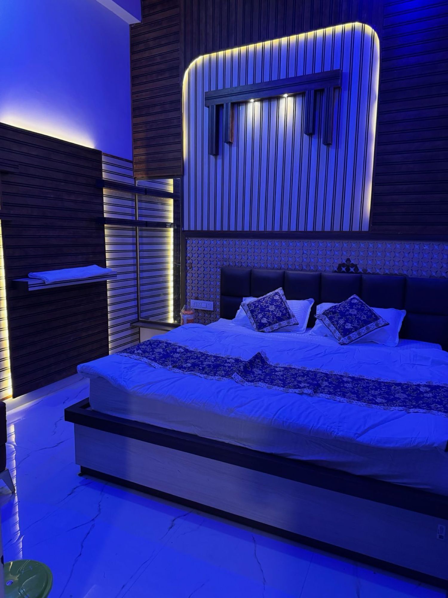 Un dormitorio moderno con una cama grande, estanterías empotradas y un diseño de pared original.