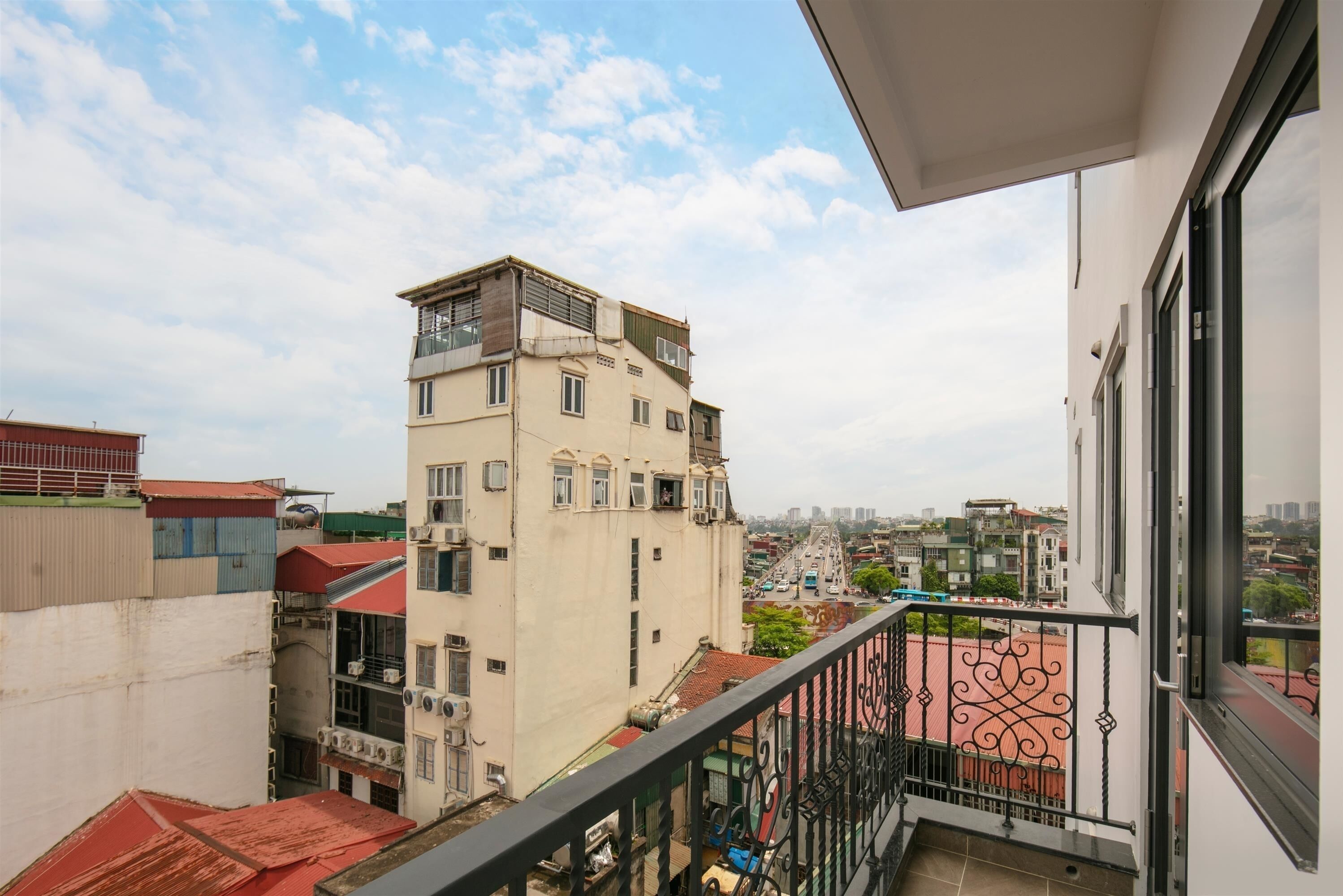 A high-rise building with multiple balconies and a view of a cityscape.