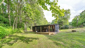 A small cabin with a porch, surrounded by lush greenery and trees. - BBQ Ready: ‘Retreat on Rice’ Near Licking River (Cynthiana)