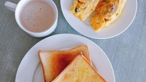 Two plates of toast and a cup of coffee on a table. - Otsal Villa (Leh)