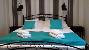 A bed with a metal frame, two pillows, a blanket, and two bedside lamps. - Charming house in Tápiószentmárton (Tápiószentmárton)